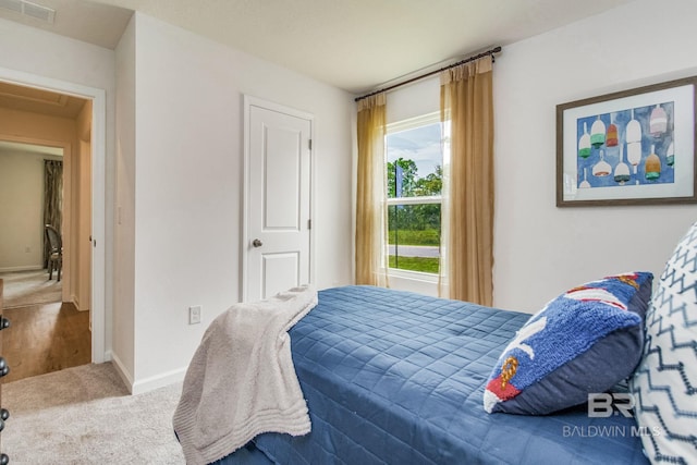 carpeted bedroom featuring visible vents and baseboards