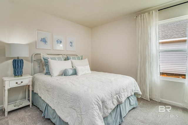 bedroom with baseboards and light colored carpet