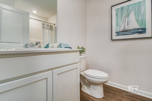 full bathroom featuring a shower with shower curtain, toilet, vanity, wood finished floors, and baseboards