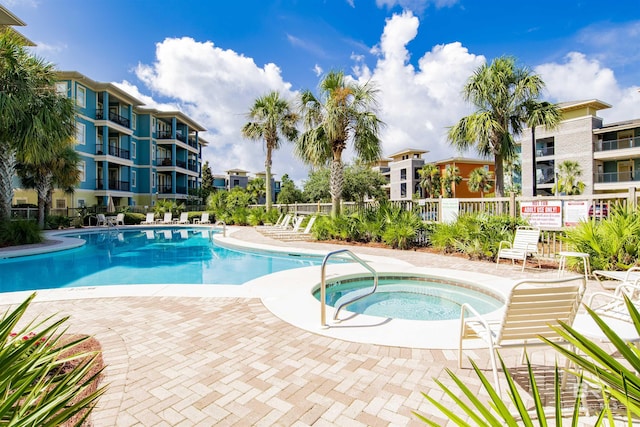 view of swimming pool featuring a community hot tub and a patio area