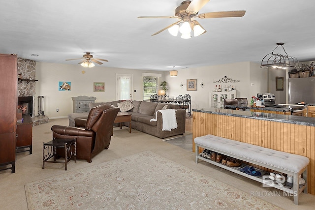 24675 Ulrich Ln, Elberta, AL 36530 - living area featuring a ceiling fan, light carpet, and a stone fireplace