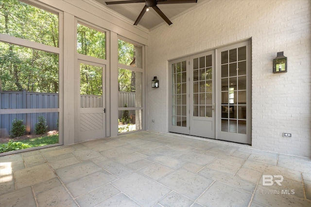 unfurnished sunroom with ceiling fan and plenty of natural light