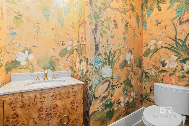 bathroom with wallpapered walls, toilet, and vanity