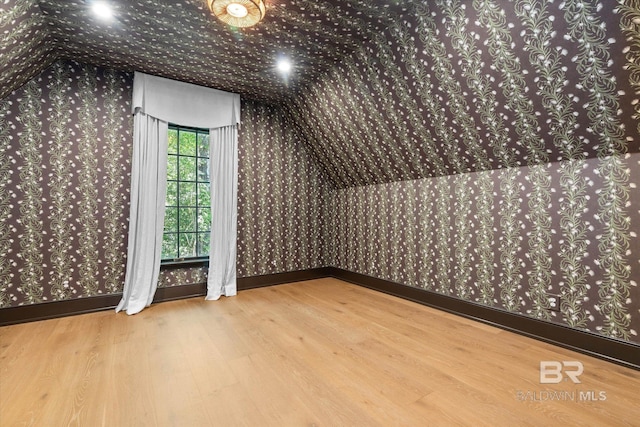 bonus room featuring wallpapered walls, wood finished floors, and baseboards