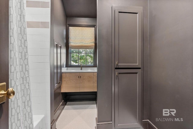 bathroom with a shower with shower curtain and a sink