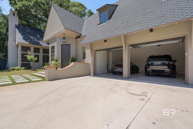 view of front of house featuring concrete driveway, an attached garage, and a chimney