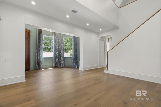 unfurnished living room featuring wood finished floors, baseboards, and recessed lighting