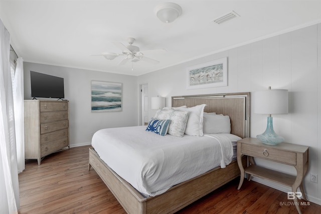 bedroom featuring crown molding, dark hardwood / wood-style floors, and ceiling fan