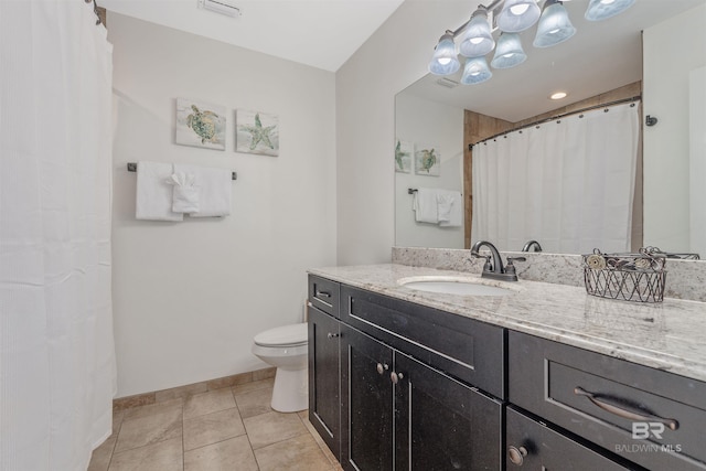 bathroom featuring tile patterned flooring, vanity, and toilet