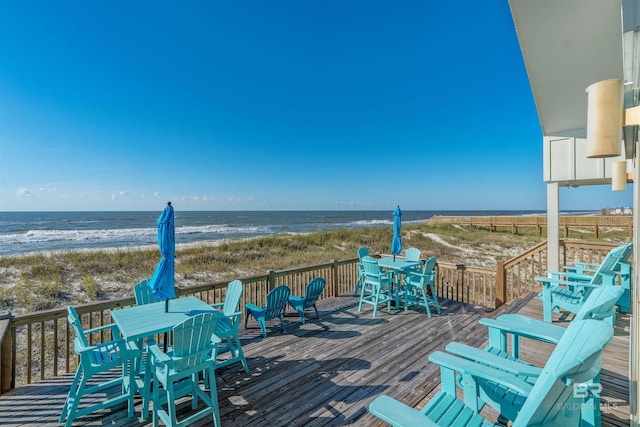 wooden terrace featuring a water view and a beach view