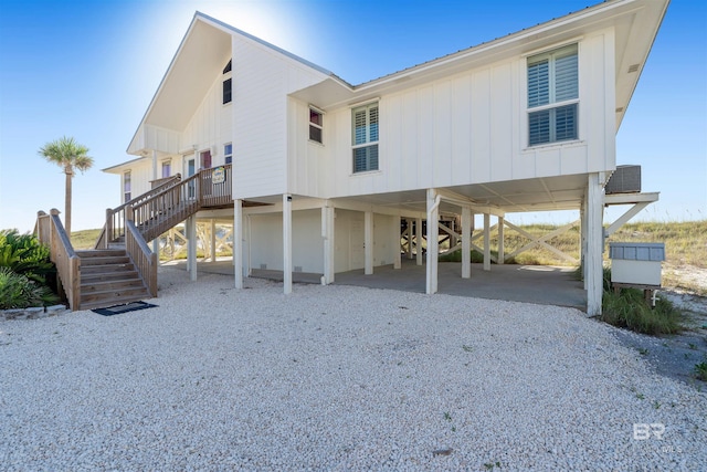 rear view of house featuring central AC unit and a carport