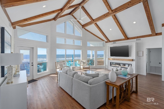 living room with hardwood / wood-style flooring, beamed ceiling, and high vaulted ceiling