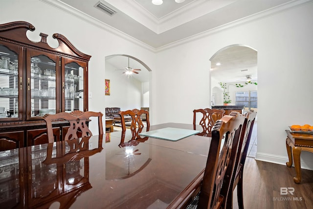 dining area with ceiling fan, arched walkways, wood finished floors, ornamental molding, and baseboards