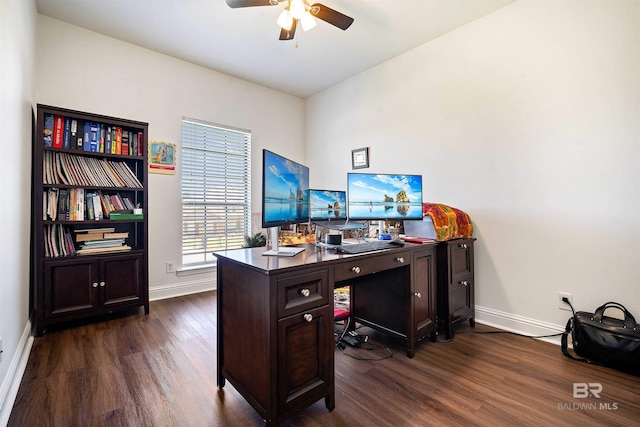 office area with dark wood-type flooring, a ceiling fan, and baseboards