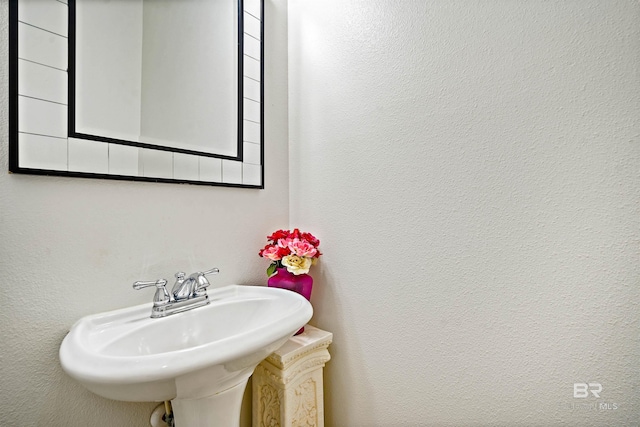 bathroom with a sink and a textured wall