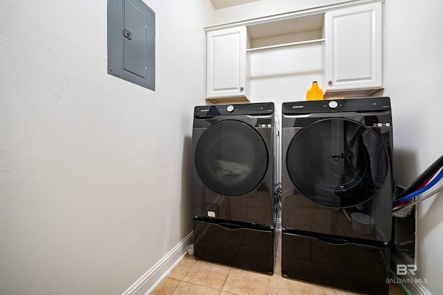 clothes washing area featuring electric panel, cabinet space, washing machine and dryer, baseboards, and light tile patterned floors