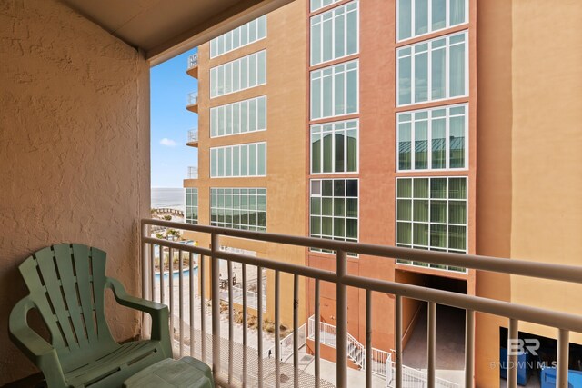 balcony with a water view and a view of the beach