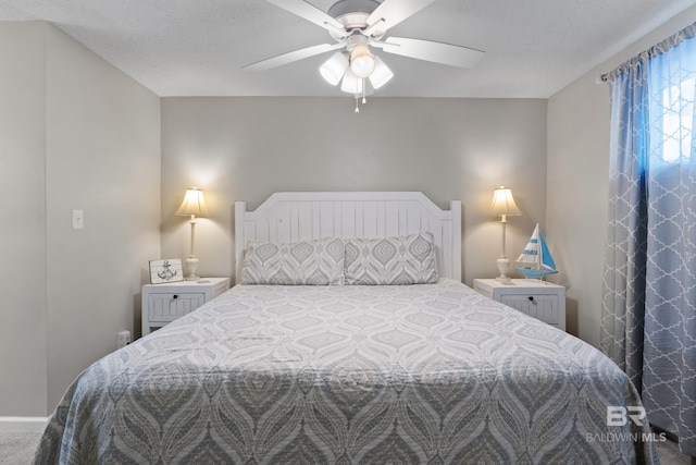 carpeted bedroom with a textured ceiling and ceiling fan