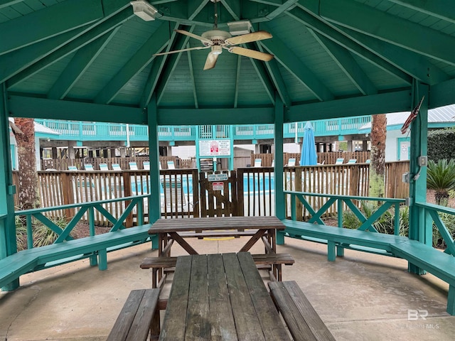 unfurnished sunroom featuring ceiling fan, wood ceiling, and lofted ceiling with beams