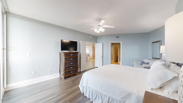 bedroom featuring baseboards, visible vents, wood finished floors, and a ceiling fan