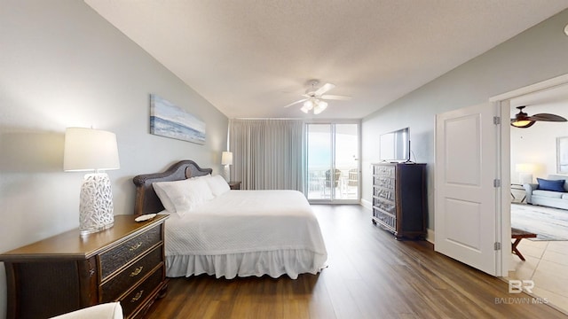 bedroom with dark wood finished floors, a wall of windows, and ceiling fan