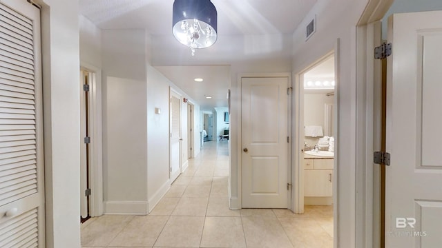 hallway with light tile patterned floors, recessed lighting, baseboards, and visible vents