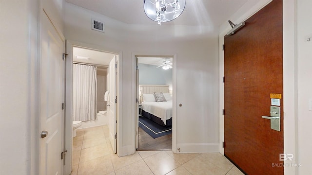 hall featuring light tile patterned flooring, baseboards, and visible vents