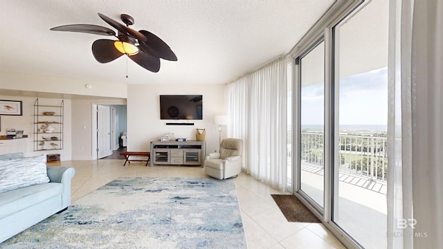 living area featuring a textured ceiling, a ceiling fan, and light tile patterned floors