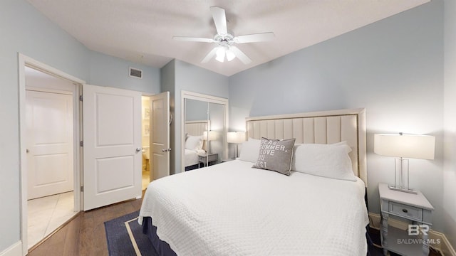 bedroom featuring visible vents, a closet, wood finished floors, and a ceiling fan