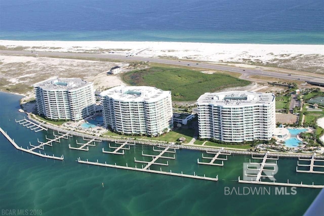 birds eye view of property with a water view, a beach view, and a city view