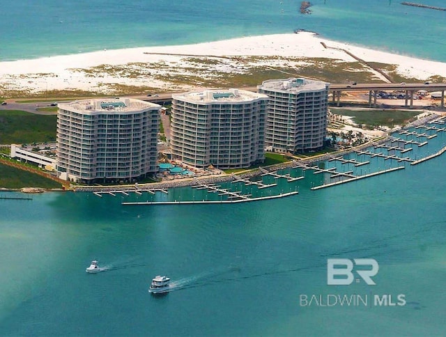 drone / aerial view with a water view, a view of city, and a beach view