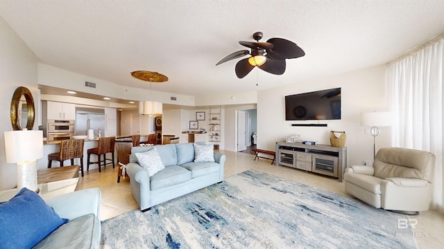 living area featuring light tile patterned flooring, a textured ceiling, visible vents, and a ceiling fan