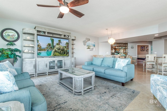 living room featuring light tile patterned flooring, ceiling fan, and a textured ceiling