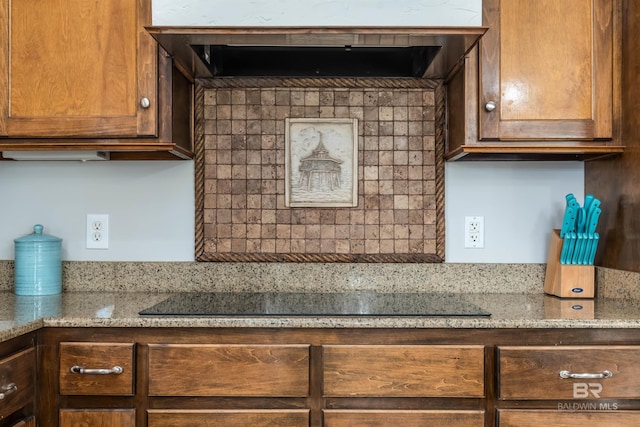 kitchen with light stone countertops and black electric cooktop