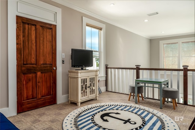 living area featuring crown molding, a wealth of natural light, and light carpet