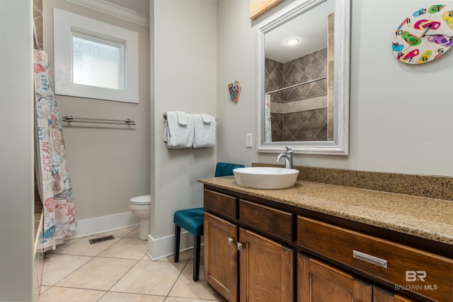 bathroom featuring crown molding, tile flooring, toilet, and vanity