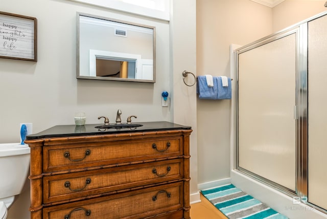 bathroom with toilet, vanity, and an enclosed shower