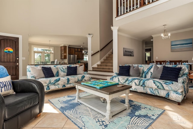 tiled living room with decorative columns, a notable chandelier, and crown molding