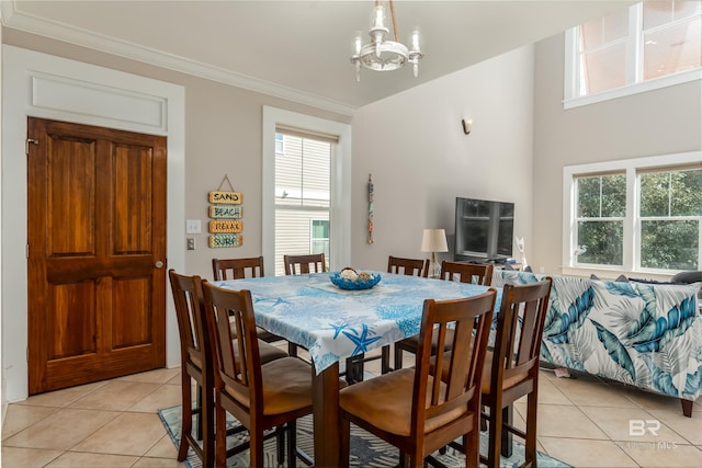 dining room featuring light tile flooring, ornamental molding, and a notable chandelier