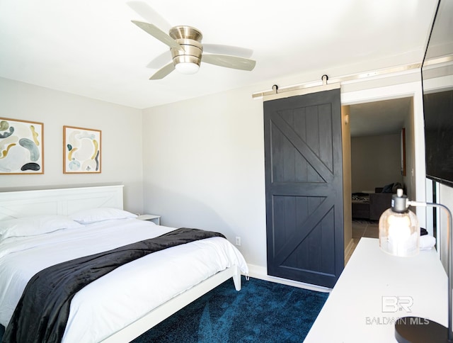 carpeted bedroom featuring ceiling fan and a barn door