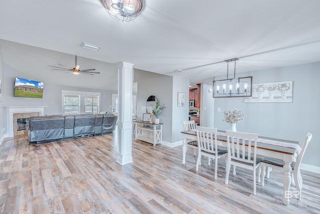 dining space featuring vaulted ceiling, ceiling fan, light hardwood / wood-style floors, and decorative columns