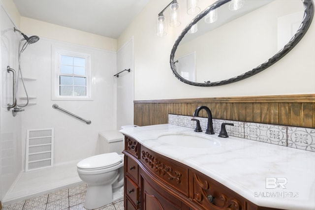 bathroom with walk in shower, vanity, toilet, and tile patterned floors