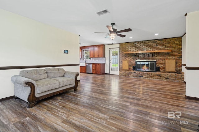 living room featuring dark wood-type flooring, a fireplace, and ceiling fan