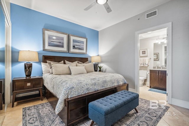 bedroom with visible vents, ensuite bathroom, a sink, light tile patterned flooring, and baseboards