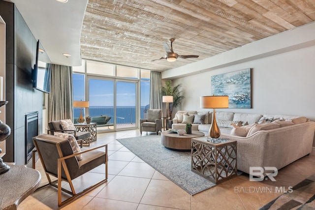 living room featuring tile patterned flooring, wooden ceiling, a ceiling fan, and expansive windows