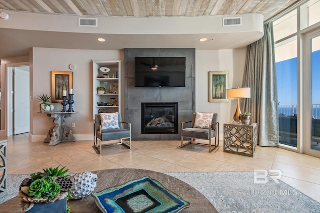 tiled living room featuring recessed lighting, visible vents, baseboards, and a tile fireplace