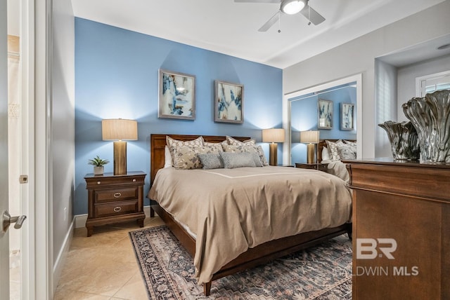 bedroom featuring light tile patterned floors, a ceiling fan, and baseboards