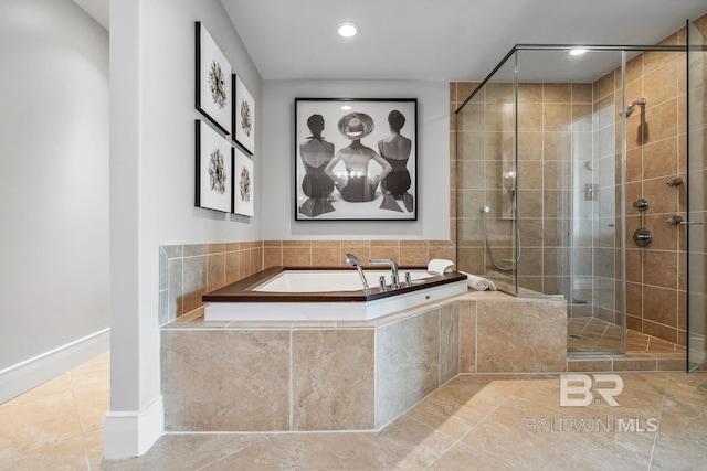 bathroom with tile patterned floors, baseboards, a garden tub, and a shower stall