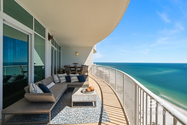 balcony featuring an outdoor hangout area, a beach view, and a water view