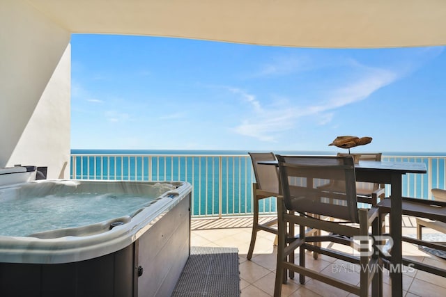 view of patio / terrace featuring a water view and a hot tub